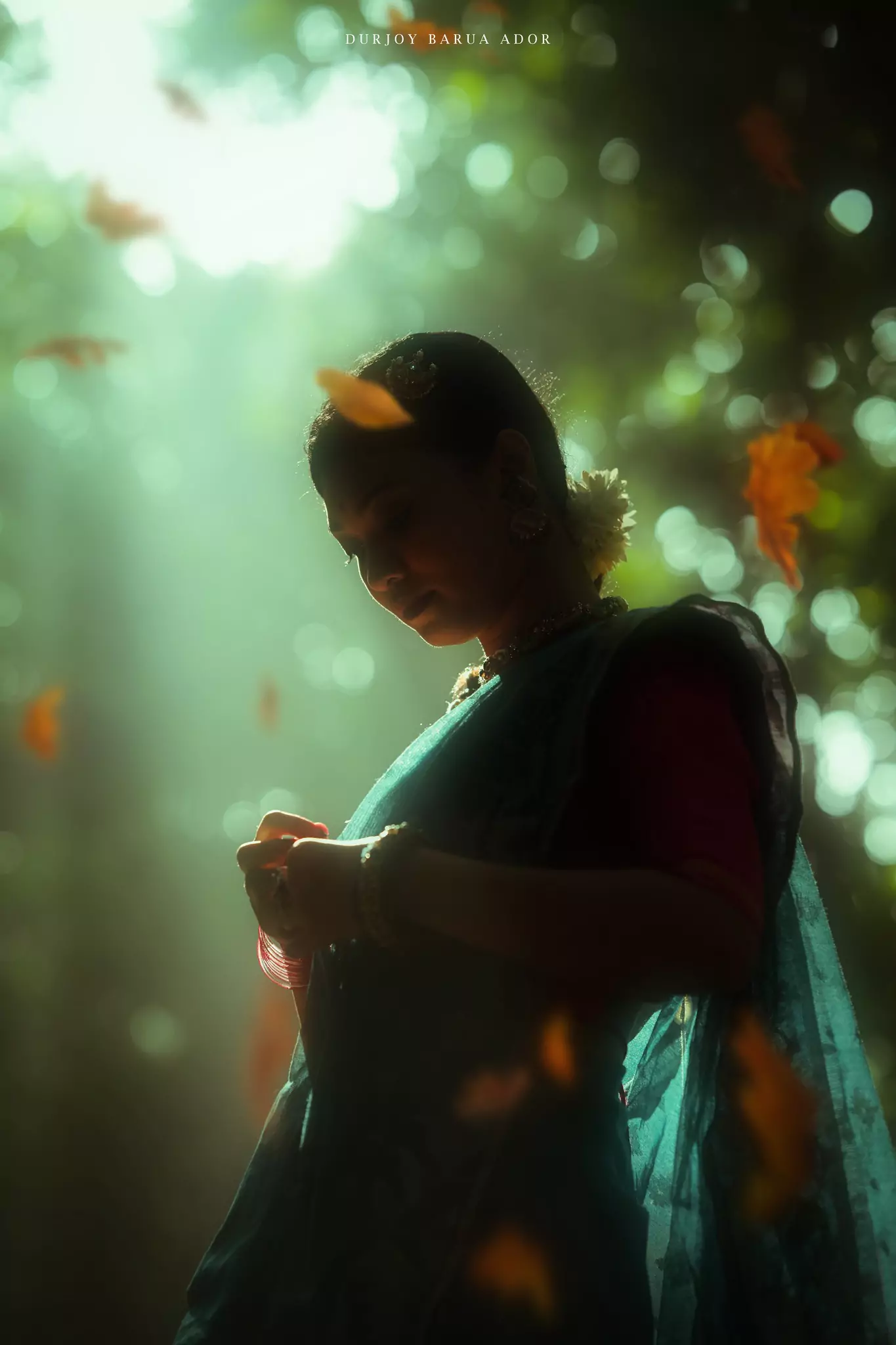 Woman in traditional attire standing in soft natural light with a dreamy background.